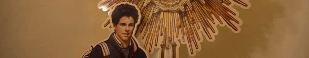 A cut-out of St. Carlo Acutis next to the Blessed Sacrament.