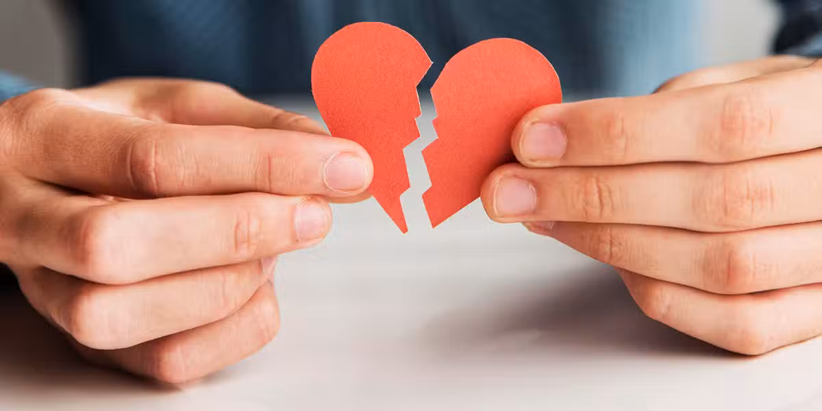 hands holding a broken/torn paper heart