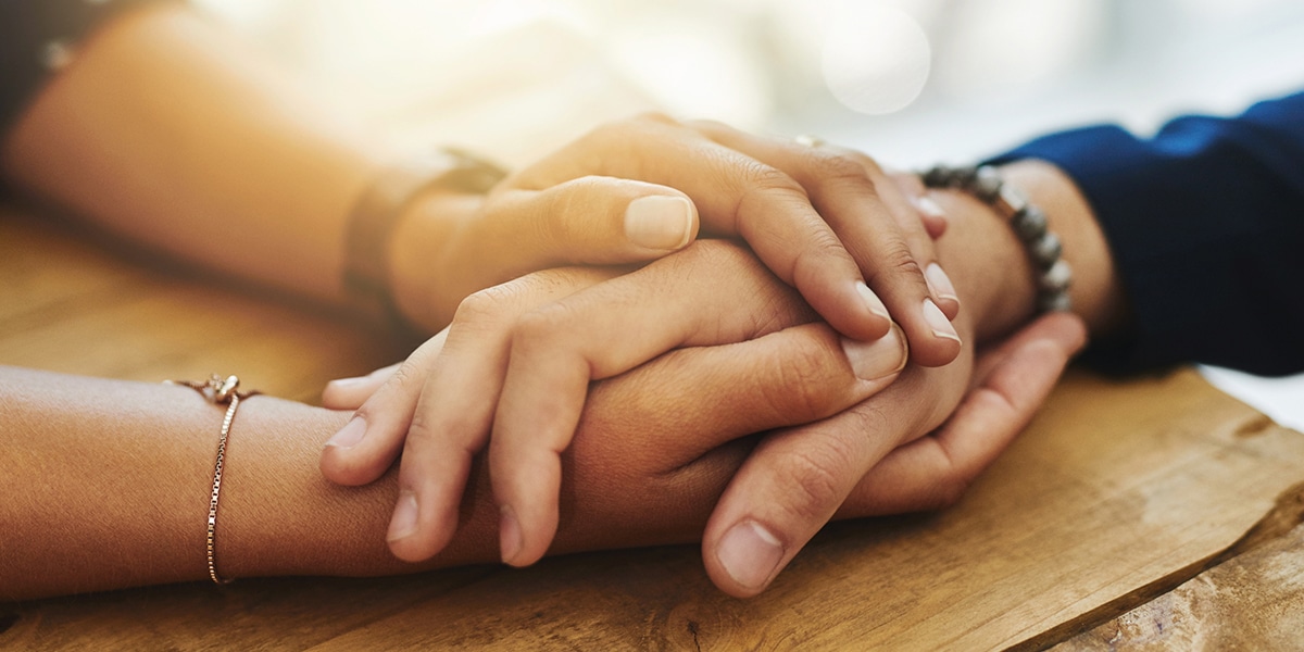 hands holding hands in compassion and giving comfort