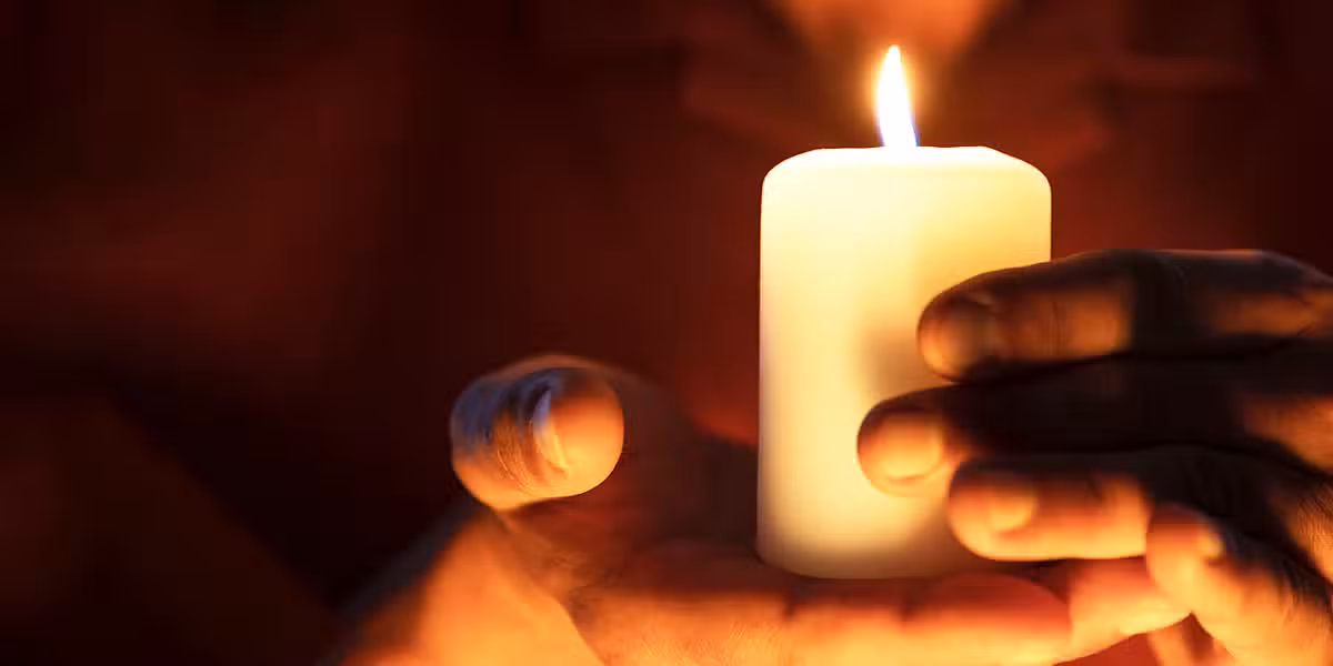 hands holding a votive candle