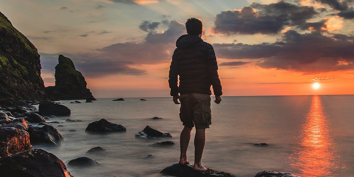 young man looking into the sky during sunset