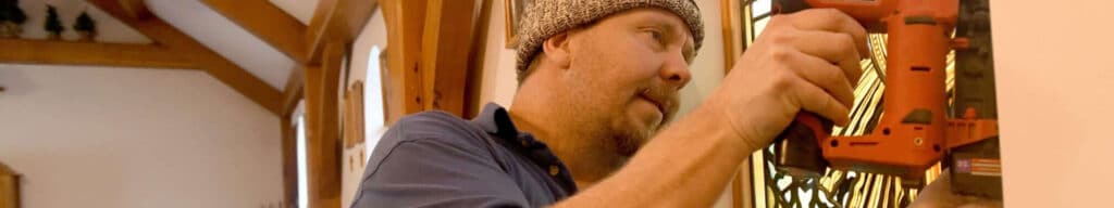 A man erects a piece of artwork of St. Carlo Acutis