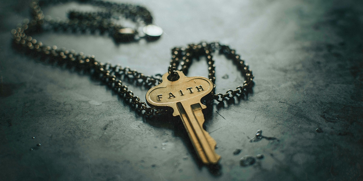 key on a chain with the words "Faith" imprinted
