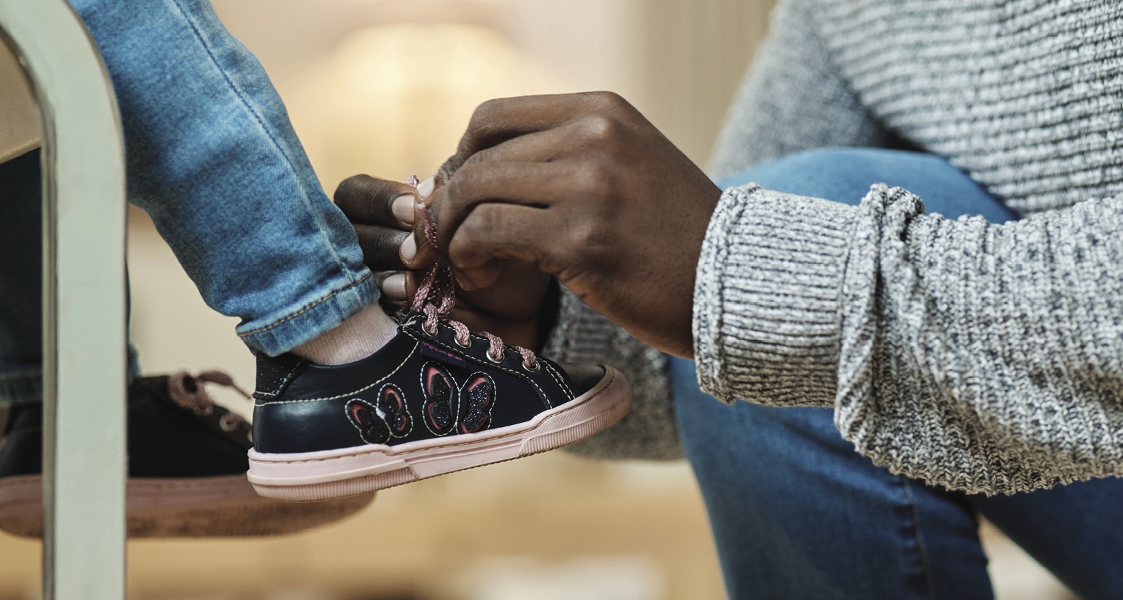 man tying a kid's shoe