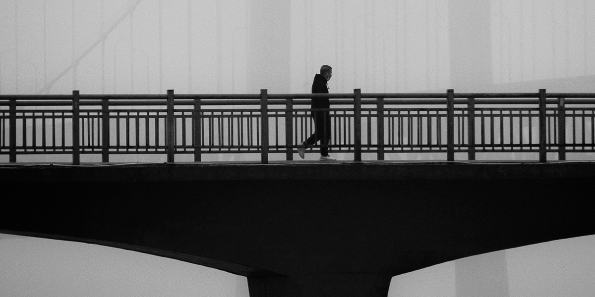 man walking over a bridge