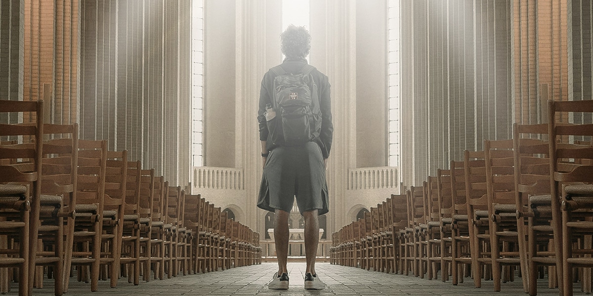 man standing in cathedral surrounded by light.