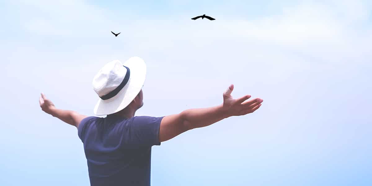 man enjoying freedom by raising his arms