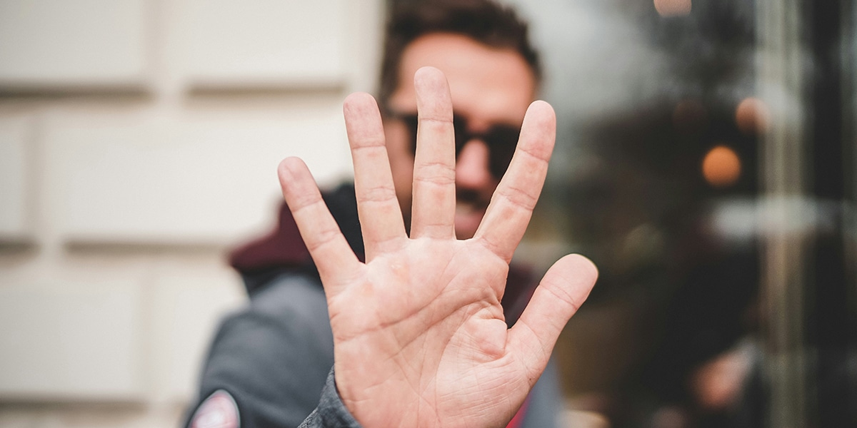 man putting his hand out in gesture of saying "no"