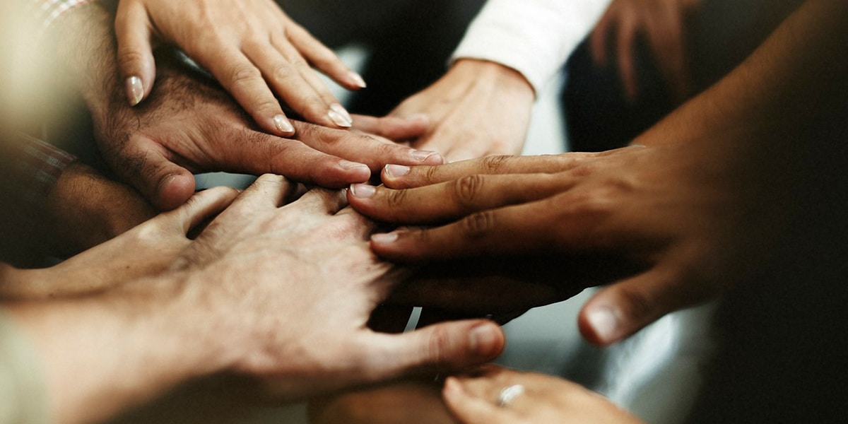 multiple hands touching, connecting with each other.
