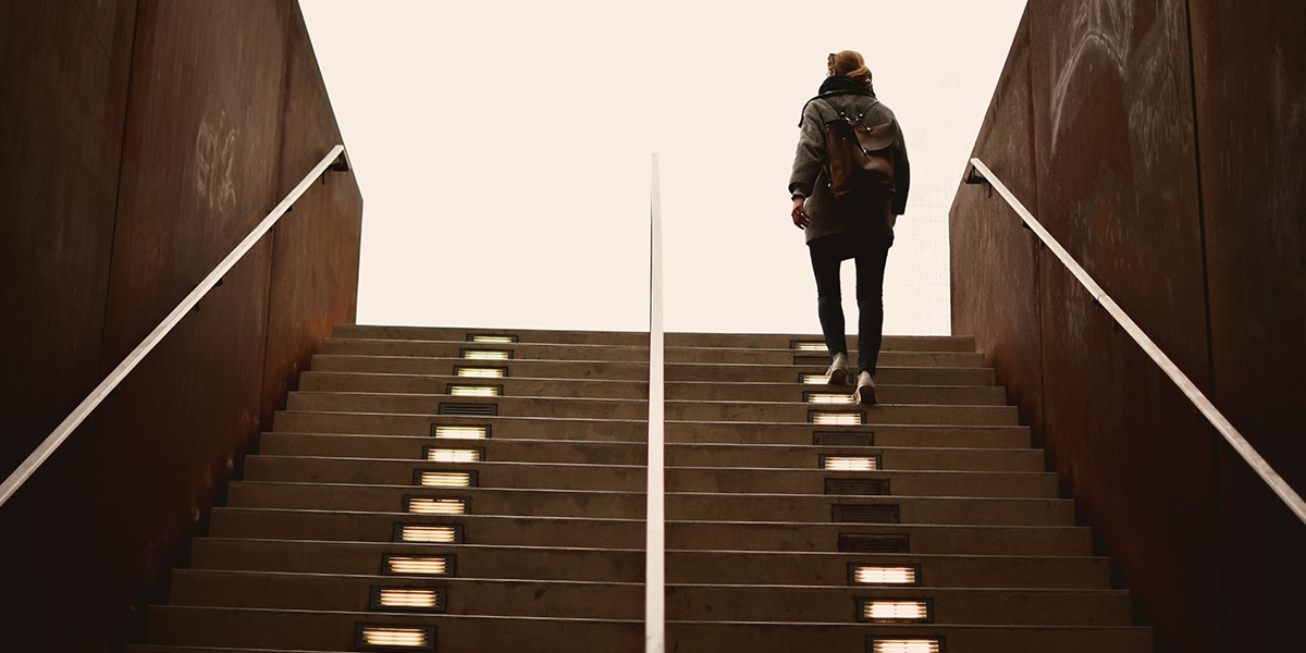 person walking up stairs overcoming a obstacle