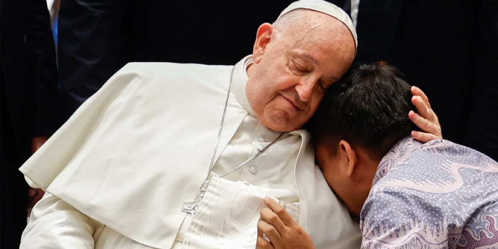 Pope Francis embraced by a child.