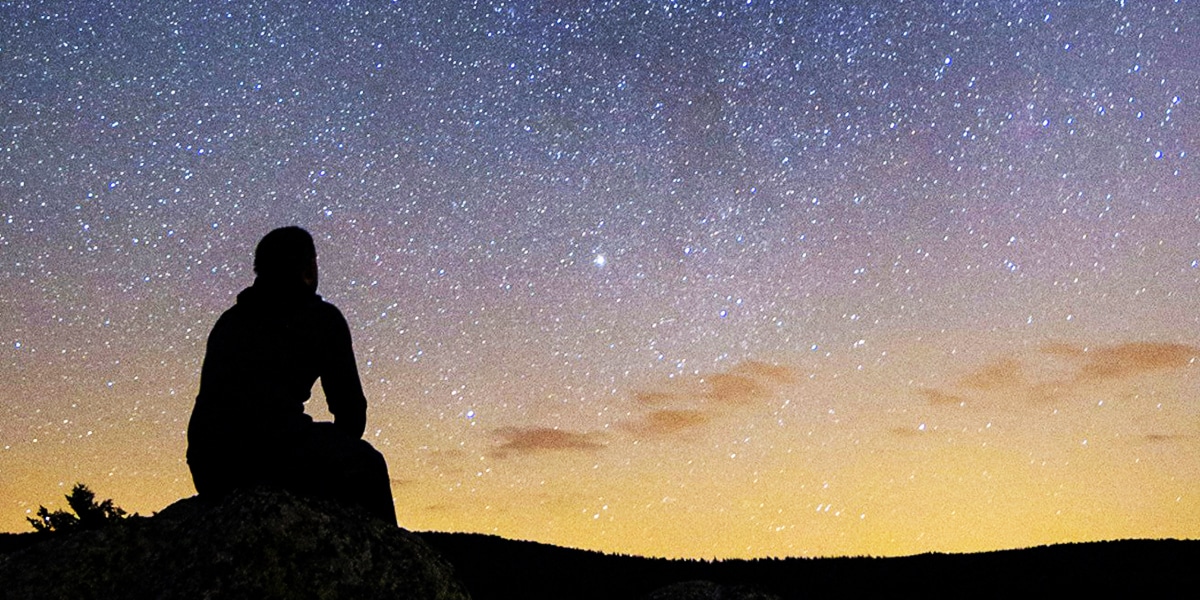 person looking into the night sky filled with stars.