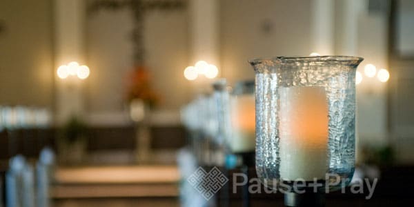Lit candle inside of a glass holder
