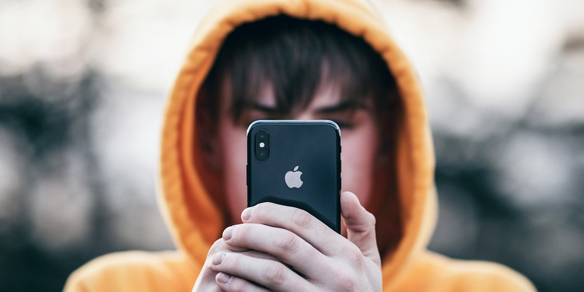 Teen wearing a buddy looking at a cell phone