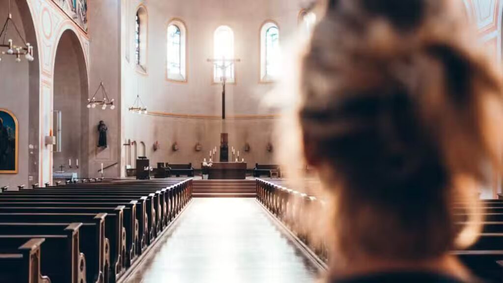 Woman stands at the back of church