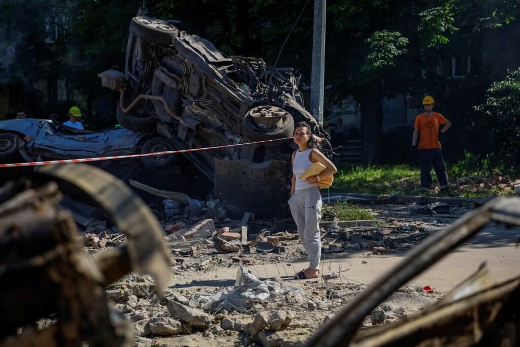 A woman looks at destroyed vehicles at the site of a damaged school, which was hit during Russian drone and missile strikes, amid Russia's attack on Ukraine, in Kyiv, Ukraine July 4, 2025. (OSV News photo/Alina Smutko, Reuters)