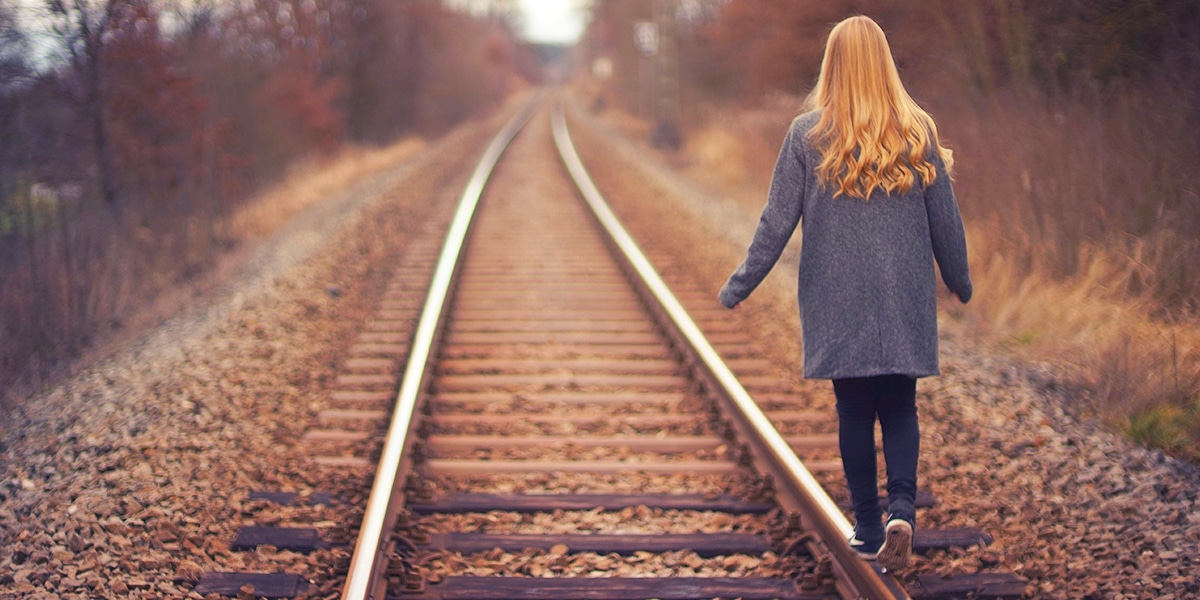 woman balancing on train tracks