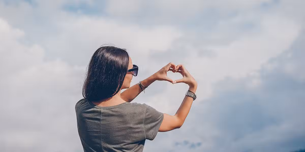 woman forming a heart with her hands.