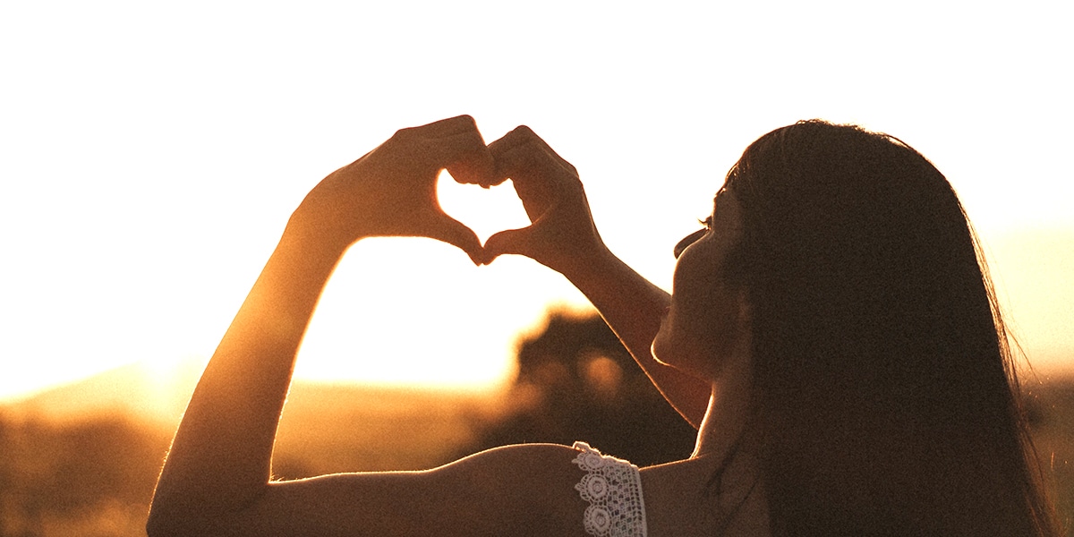 woman making the sign of the heart with her hands