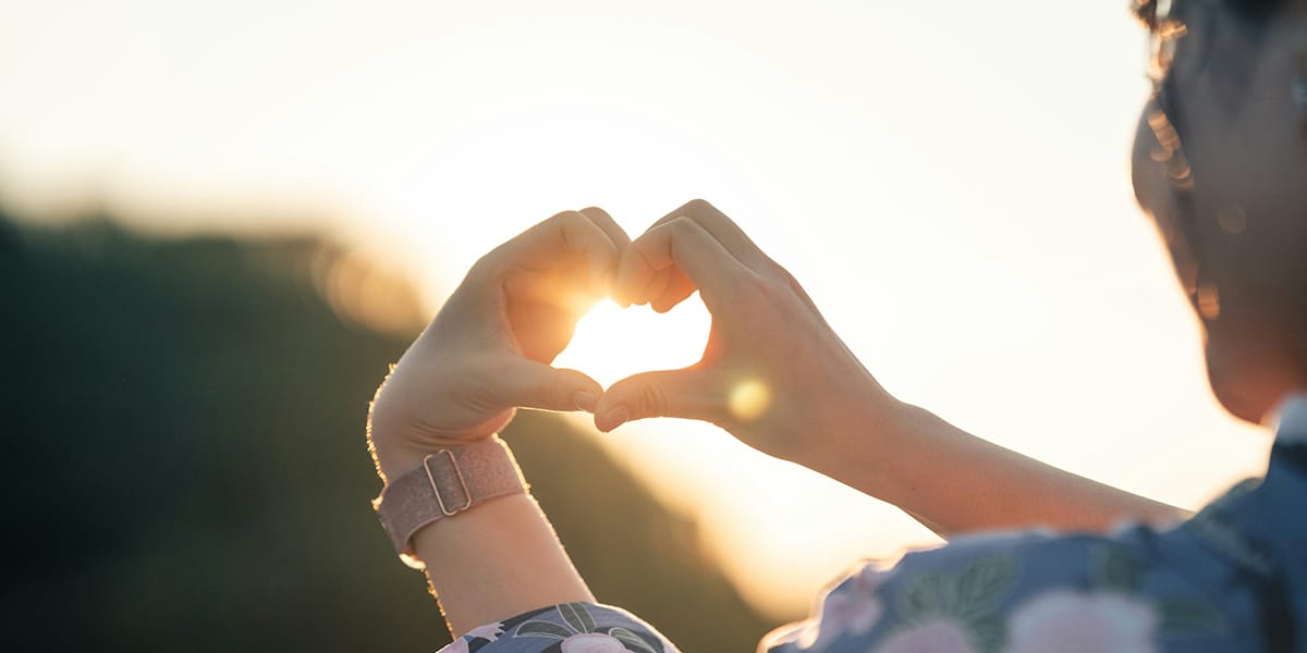 woman forming a heart with her hands
