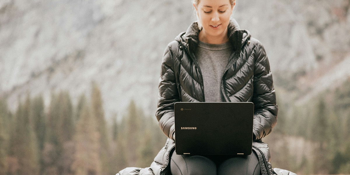 woman sitting outside while working on a laptop