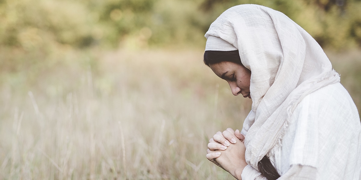 woman wearing a head covering, praying