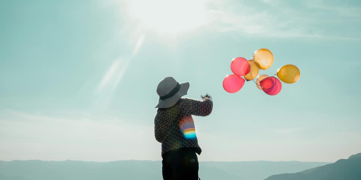 woman releasing balloons into the sky
