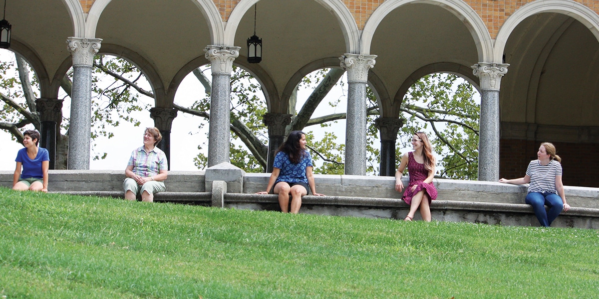 women sit together at a park