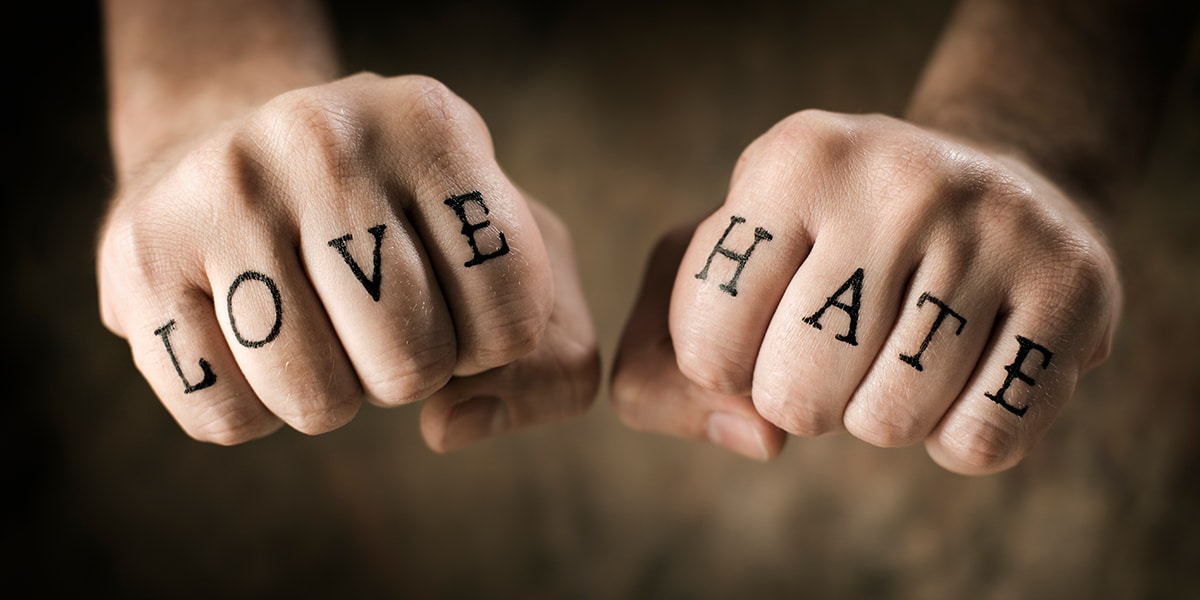 words love and hate written on the fingers of two hands