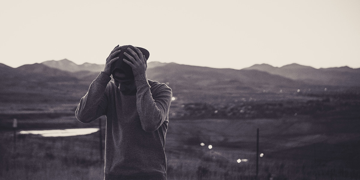Young person with regrets holding his hands over his head